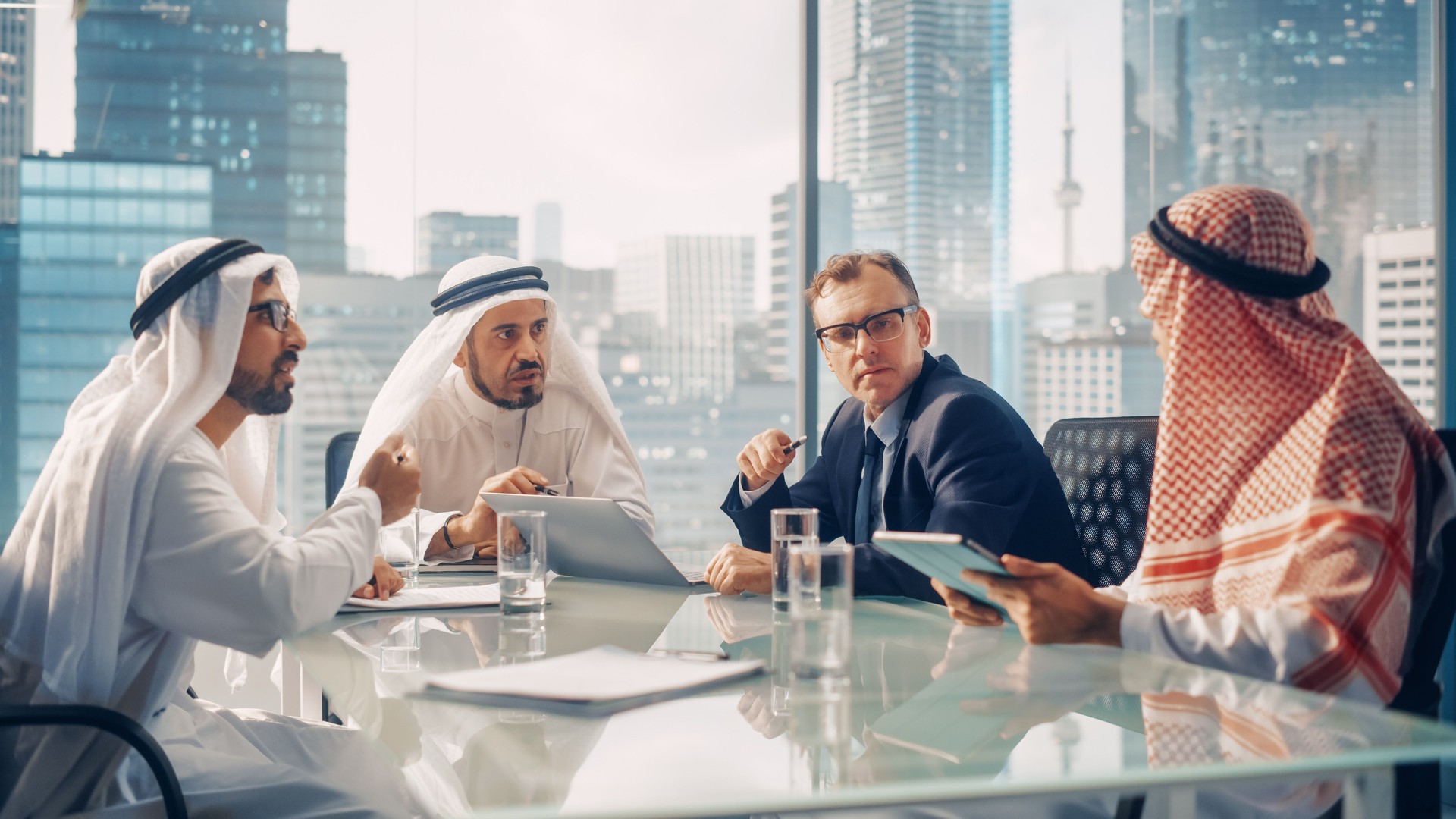 International Business Consultant Advices on Diversification of Investment Portfolio to Successful Arab Company Owners. Multicultural Meeting in Modern Office Between American and Emirati Businessman